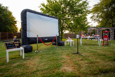 Backyard Movie Party Setup with Inflatable Projector and Popcorn Bar